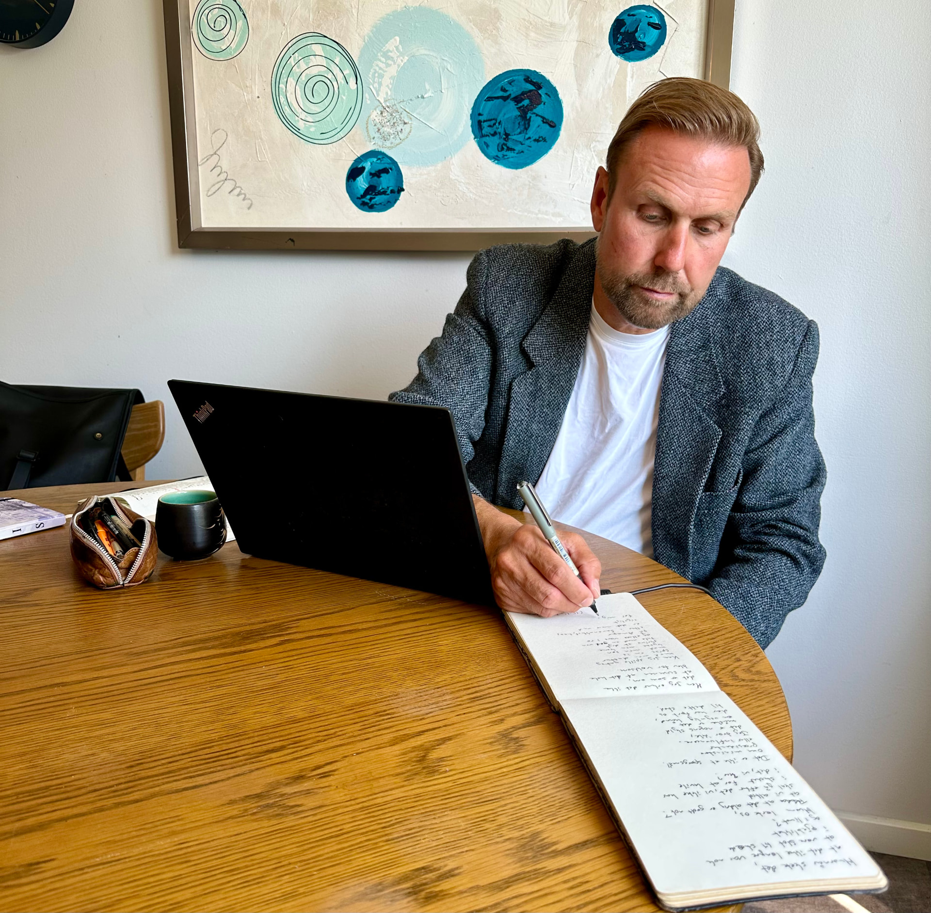 Ole Ditlev Nielsen skriver i sin notesbog ved computeren